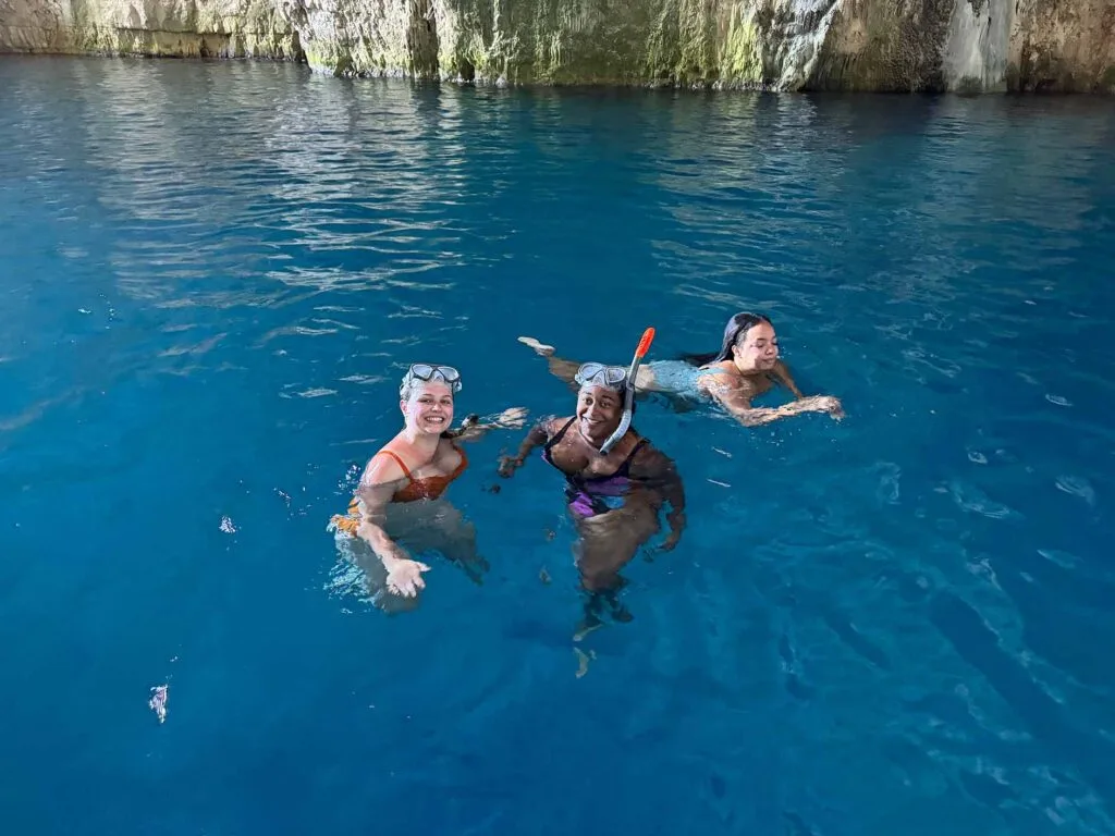 Tourists snorkeling inside Haxhi Ali Cave in Vlore, Albania, enjoying the crystal-clear blue waters and stunning cave formations. A perfect adventure for travelers seeking a unique boat trip and snorkeling experience in the Albanian Riviera.