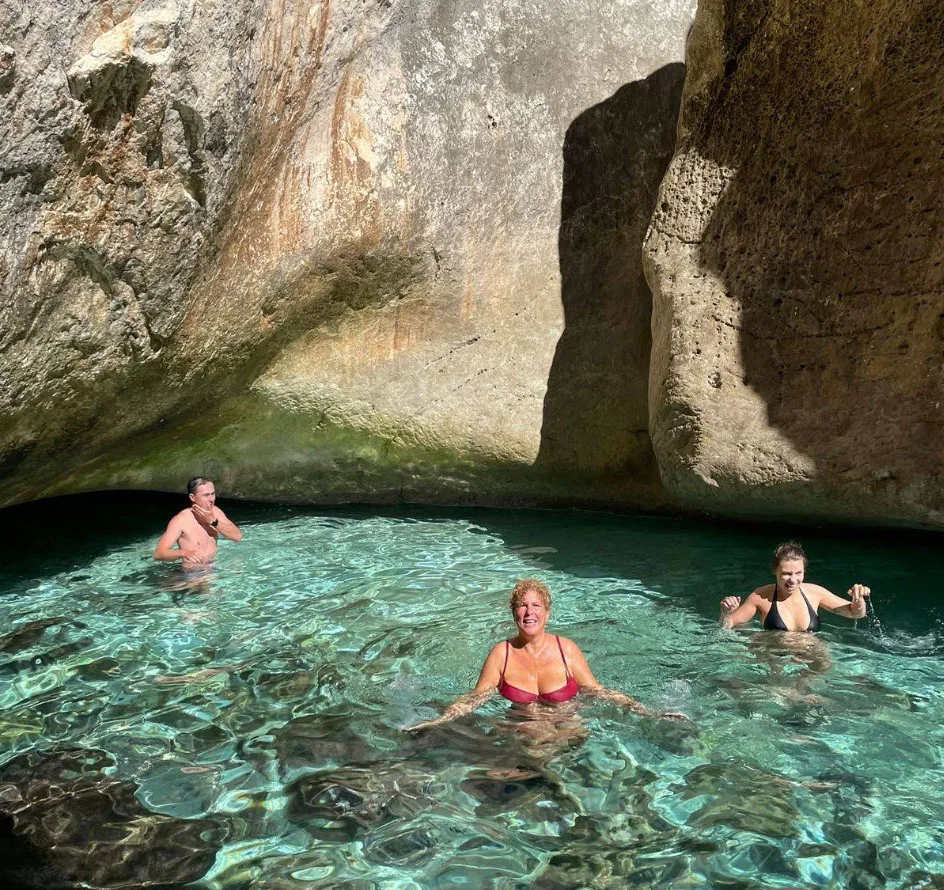 Tourists swim in a hidden natural pool surrounded by rugged rock formations on the Karaburun Peninsula, Albania. The crystal-clear turquoise water reflects the sunlight, creating a mesmerizing glow. This secluded spot is a must-visit destination for travelers exploring Karaburun's pristine beaches, sea caves, and untouched nature. Perfect for adventure seekers, snorkeling enthusiasts, and those looking for a unique swimming experience in Albania's most stunning coastal region.